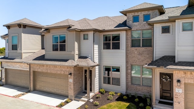 townhome / multi-family property featuring brick siding and roof with shingles