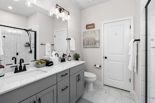 bathroom featuring a sink, marble finish floor, a shower stall, and double vanity