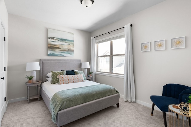 bedroom with light colored carpet and baseboards