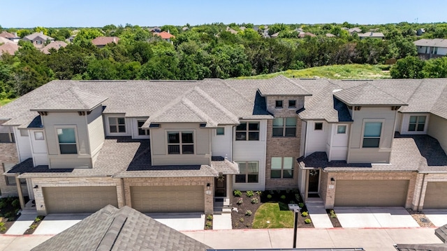 view of property featuring brick siding, a residential view, and driveway