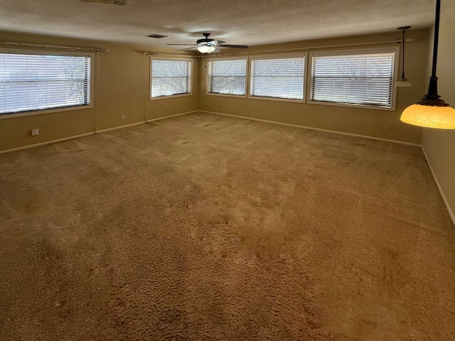 unfurnished room with light colored carpet, baseboards, a textured ceiling, and ceiling fan