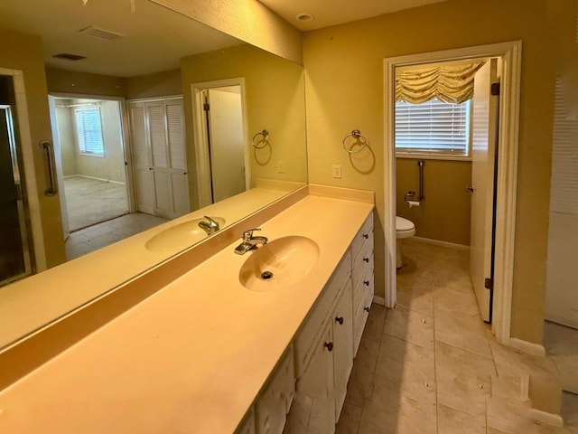 bathroom featuring vanity, visible vents, baseboards, tile patterned floors, and toilet