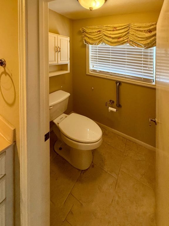 bathroom featuring tile patterned floors, toilet, and baseboards