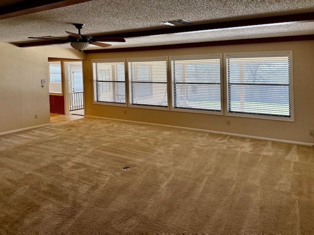 spare room with carpet flooring, visible vents, a textured ceiling, and baseboards