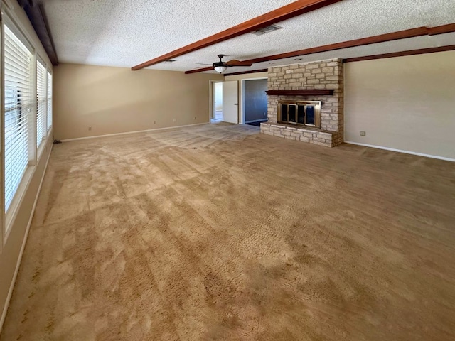 unfurnished living room with visible vents, beam ceiling, a textured ceiling, carpet floors, and a fireplace