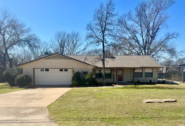 ranch-style house featuring a front yard, driveway, roof with shingles, an attached garage, and board and batten siding