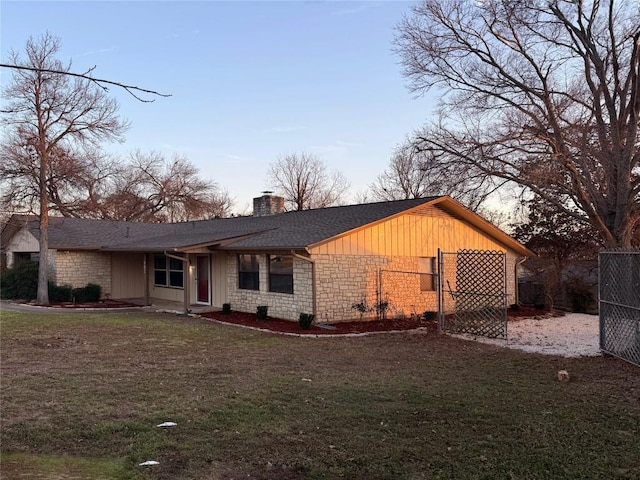 view of front of property featuring fence, roof with shingles, a front yard, a chimney, and stone siding