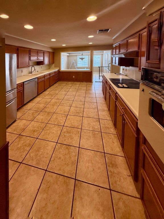 kitchen with light tile patterned floors, visible vents, appliances with stainless steel finishes, and light countertops