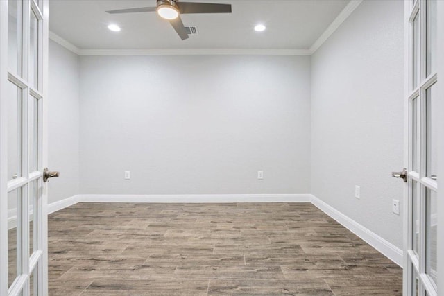 spare room with wood finished floors, french doors, and ornamental molding