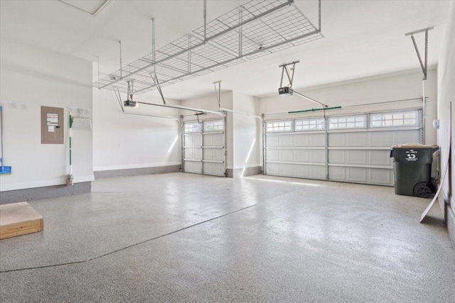 garage featuring electric panel, a garage door opener, and baseboards