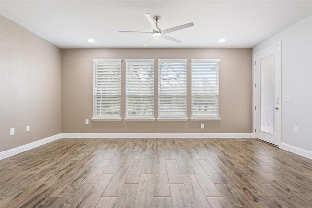 unfurnished room featuring a ceiling fan, recessed lighting, wood finished floors, and baseboards