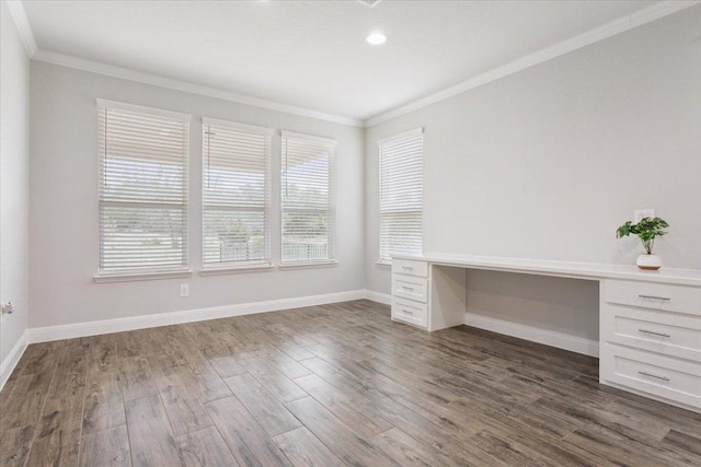 unfurnished office featuring dark wood-style floors, built in study area, baseboards, and ornamental molding