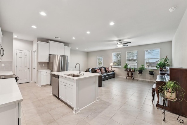 kitchen with visible vents, a sink, open floor plan, appliances with stainless steel finishes, and light countertops