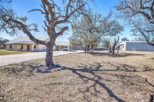 view of front of property with metal roof, a front yard, and driveway