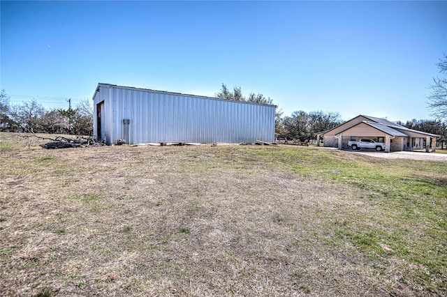 view of yard with a carport, an outdoor structure, and a pole building