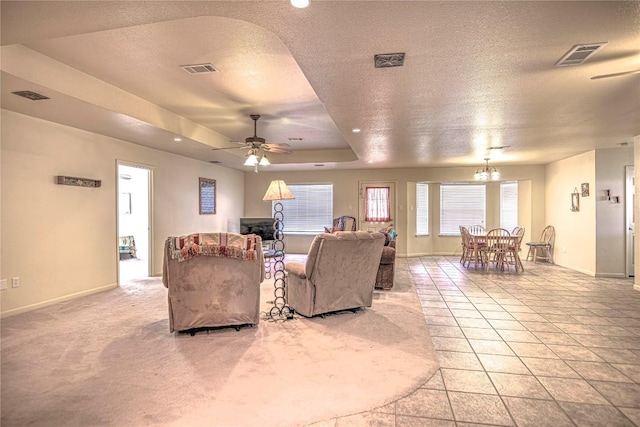 living room featuring visible vents, a textured ceiling, and a tray ceiling