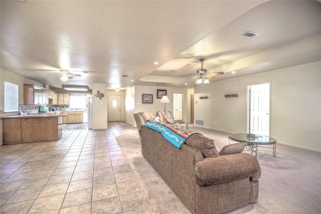 living room with baseboards, visible vents, and a textured ceiling