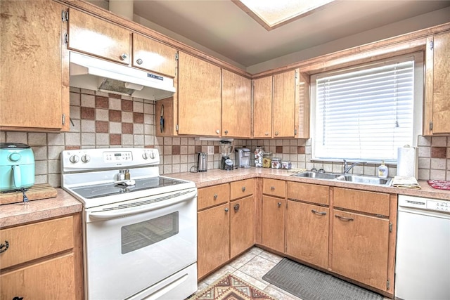 kitchen featuring under cabinet range hood, a sink, backsplash, white appliances, and light countertops