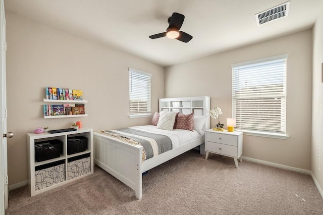 carpeted bedroom with baseboards, visible vents, and ceiling fan