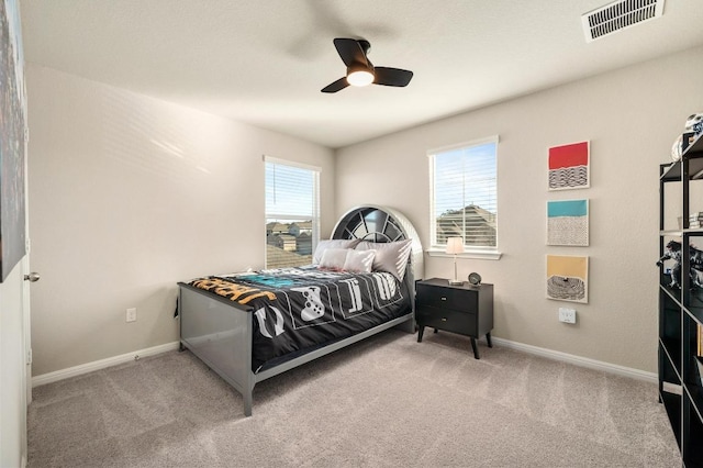 carpeted bedroom featuring visible vents, multiple windows, and baseboards