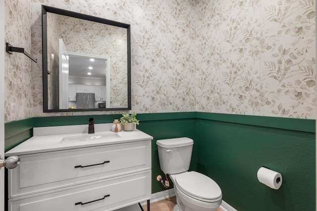 bathroom featuring wallpapered walls, toilet, and vanity