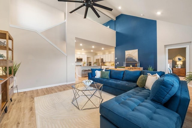 living room featuring light wood-type flooring, high vaulted ceiling, recessed lighting, baseboards, and ceiling fan