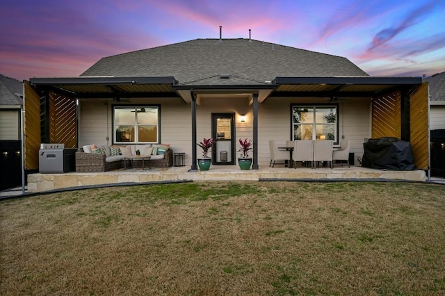 rear view of property featuring a lawn, roof with shingles, outdoor lounge area, and a patio area