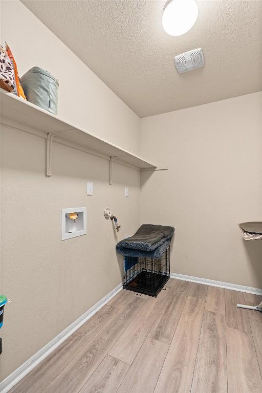 laundry room with visible vents, washer hookup, a textured ceiling, wood finished floors, and laundry area