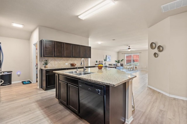 kitchen featuring visible vents, light wood-type flooring, black dishwasher, decorative backsplash, and a sink