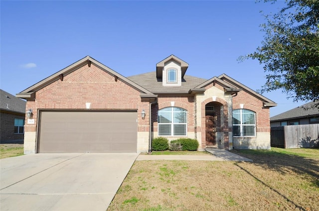 view of front of house featuring a front lawn, brick siding, an attached garage, and fence