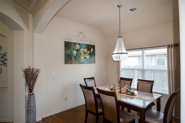 dining room with baseboards, visible vents, dark wood finished floors, arched walkways, and vaulted ceiling