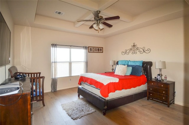 bedroom with visible vents, coffered ceiling, baseboards, and wood finished floors