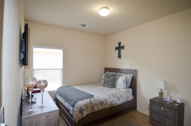 bedroom with wood finished floors and visible vents