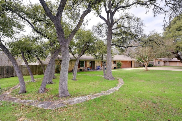 single story home with a front yard, fence, driveway, an attached garage, and brick siding