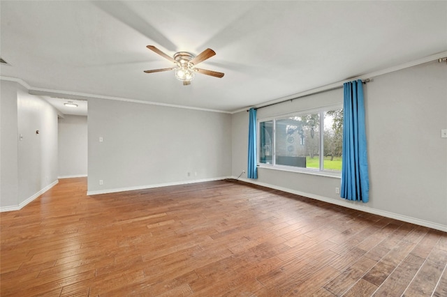 spare room with light wood-style flooring, visible vents, baseboards, and ornamental molding