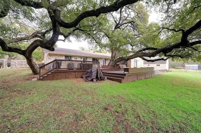 rear view of property with a lawn, a deck, and fence