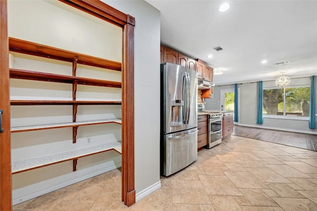 kitchen featuring visible vents, stainless steel appliances, light countertops, and baseboards