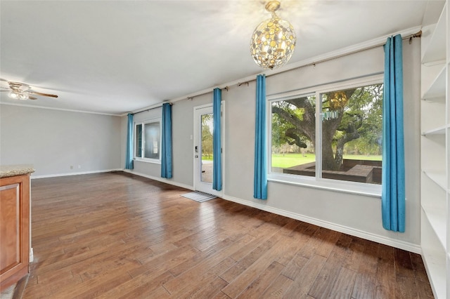 empty room featuring a ceiling fan, baseboards, and hardwood / wood-style flooring