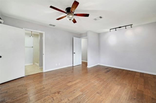 spare room with visible vents, wood-type flooring, and baseboards