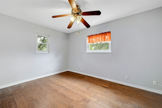 spare room with wood finished floors, baseboards, and ceiling fan