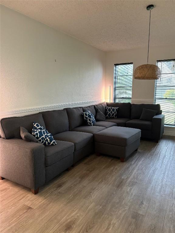 living area with light wood-style floors and a textured ceiling