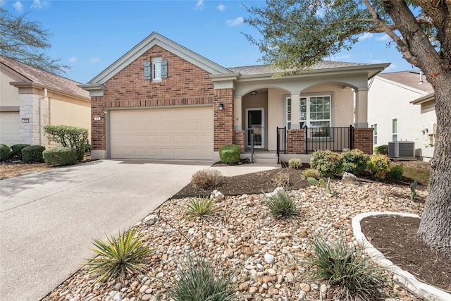 216 Farm Hill Dr, Georgetown, TX 78633 - view of front of house with a porch, central AC, concrete driveway, a garage, and brick siding
