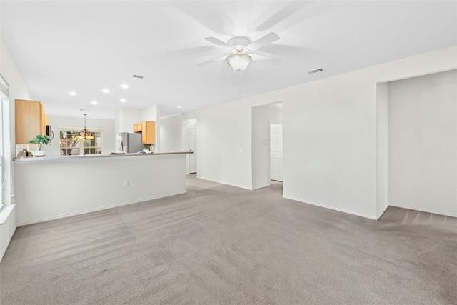 unfurnished living room with ceiling fan, recessed lighting, visible vents, and light carpet