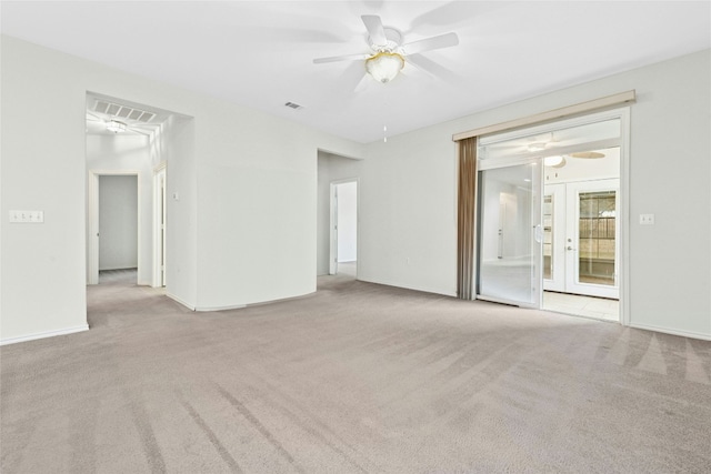 carpeted empty room featuring visible vents, baseboards, a ceiling fan, and french doors