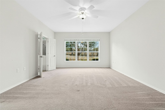 carpeted empty room featuring baseboards and ceiling fan