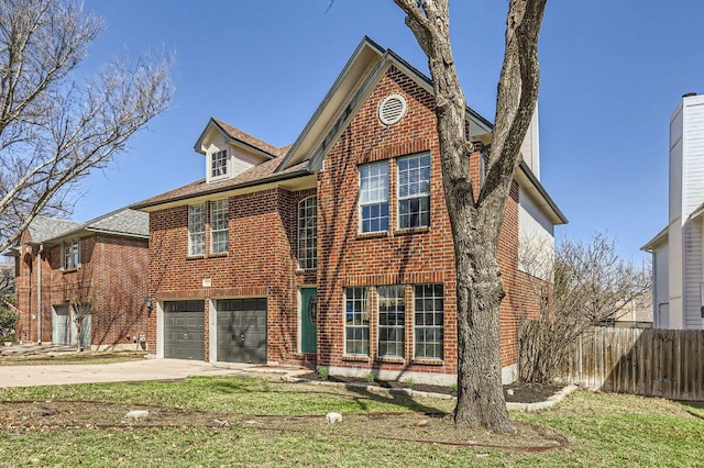 traditional home featuring a front yard, fence, concrete driveway, a garage, and brick siding