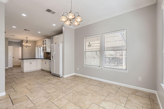 kitchen with visible vents, dark countertops, white refrigerator with ice dispenser, and an inviting chandelier