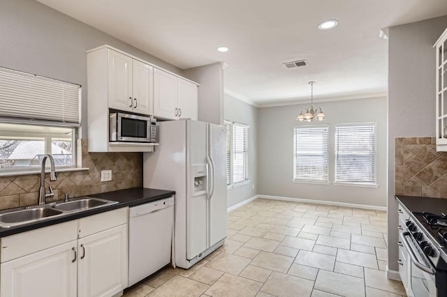 kitchen featuring visible vents, a sink, tasteful backsplash, dark countertops, and stainless steel appliances