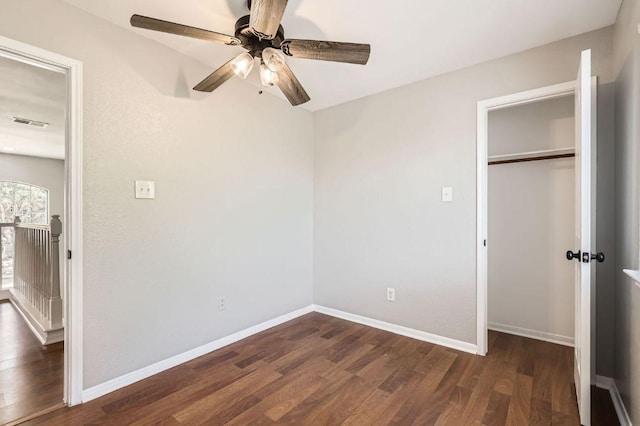 unfurnished bedroom with visible vents, baseboards, a closet, and dark wood-style floors