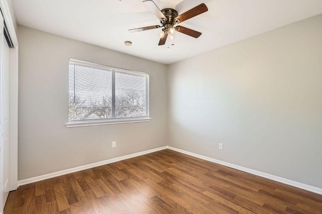 empty room with ceiling fan, baseboards, and wood finished floors